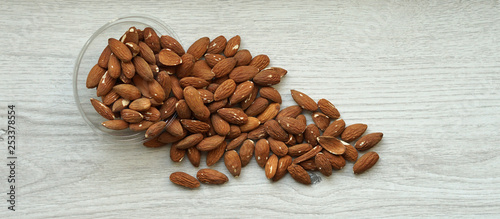 Healthy food  for background image close up almond nuts. Texture on white grey table top view. Nut on the cup plate
