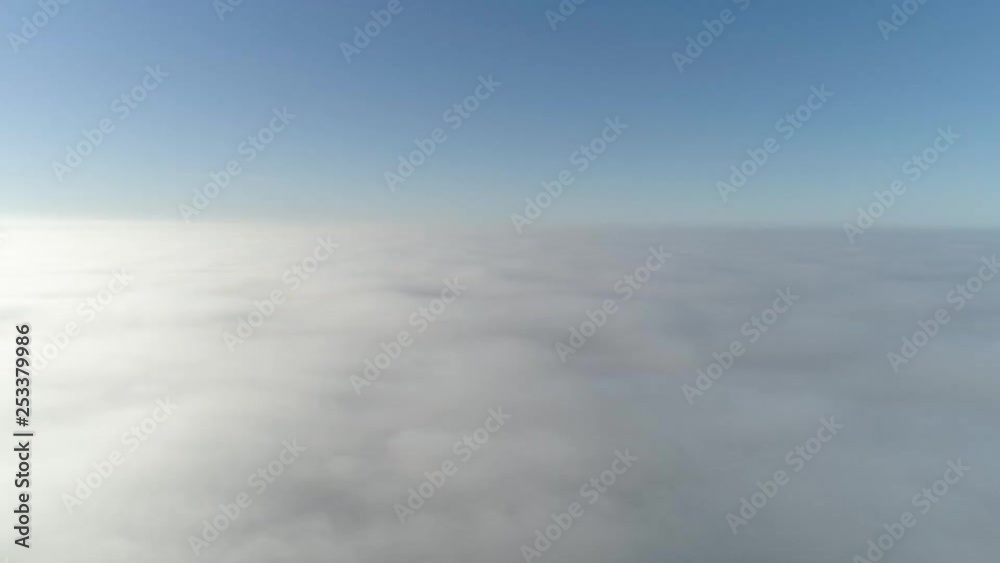 Flight over misty clouds in morning sunlight with little glory and city scape under clouds Flight over misty clouds in morning sunlight with little glory and city scape under clouds