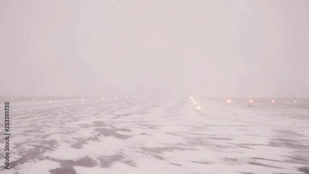 takeoff path in foggy, snowy airport, there are light turned on.