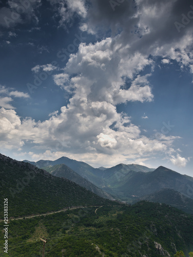 Mountain range with many peaks under a sky with heavy clouds formations