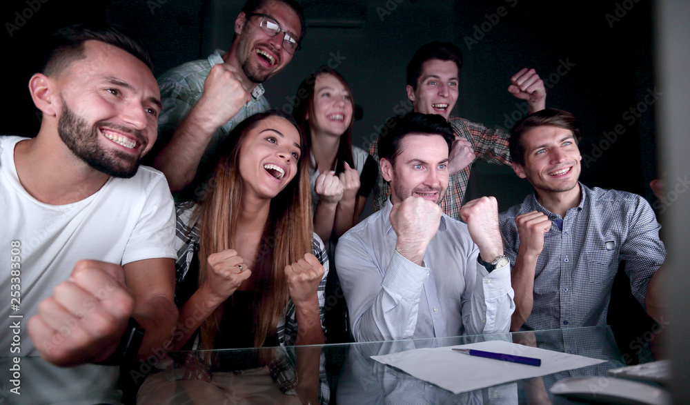 happy business team looking at computer monitor happy business team looking at computer monitor