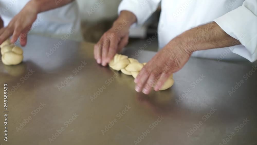 Close-up of bakers braiding dough to make braided loaves of bread Close-up of bakers braiding dough to make braided loaves of bread