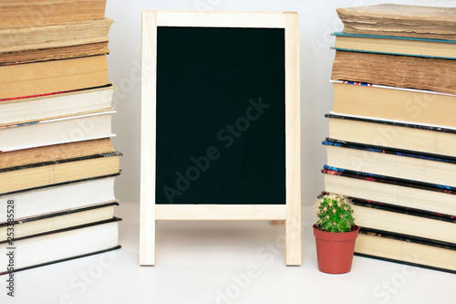 school chalkboard on the table with stacks of books. back to school. copy space. mockup