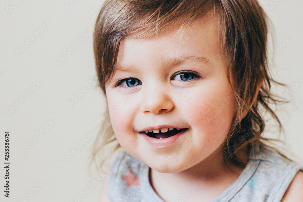 Beautiful Child Baby Girl Smiling Happy with Her Mouth Open, Blue Eyes, Closeup, Neutral Background Beautiful Child Baby Girl Smiling Happy with Her Mouth Open, Blue Eyes, Closeup, Neutral Background