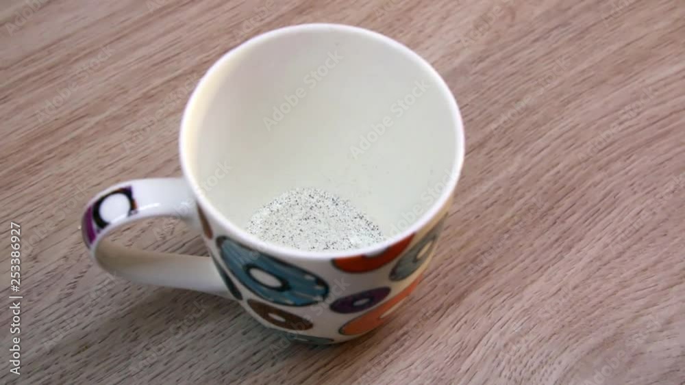 Putting cappuccino powder into a cup Putting cappuccino powder into a cup