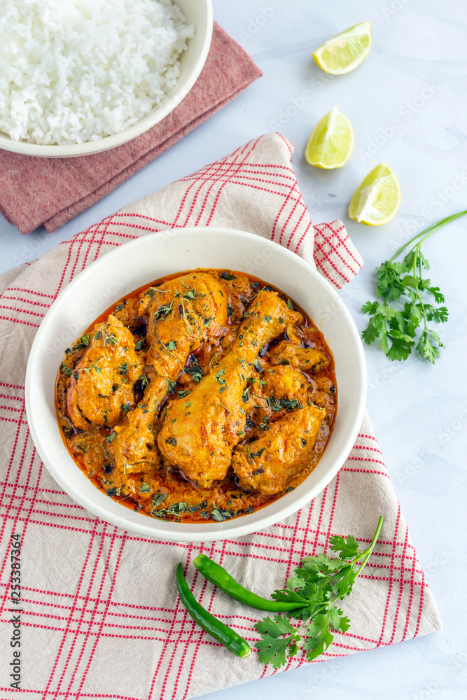 Indian Chicken Curry with Fenugreek. Methi Chicken Served in a Bowl on White Background Vertical Photo. Indian Chicken Curry with Fenugreek. Methi Chicken Served in a Bowl on White Background Vertical Photo.