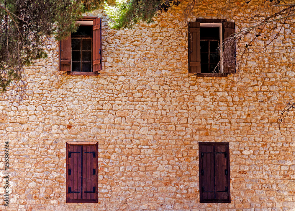 An old wall with four windows in Greece
