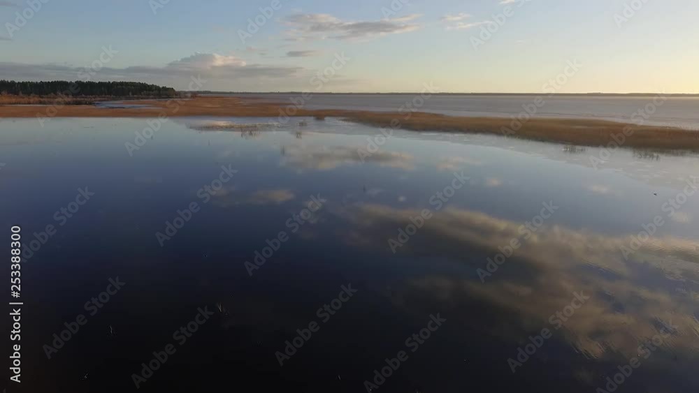 Calm lake Burtnieks with little ice and high water level in spring aerial view Calm lake Burtnieks with little ice and high water level in spring aerial view