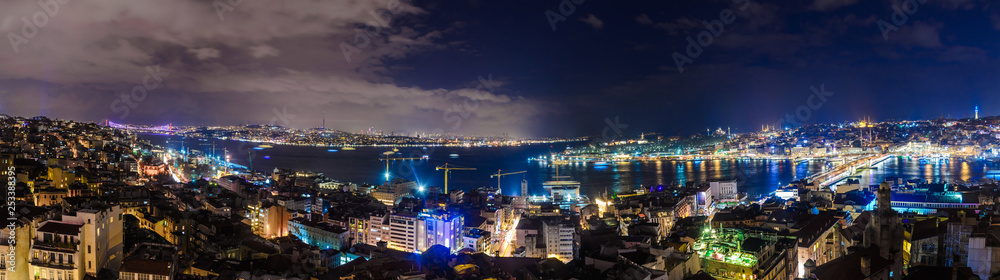 Panoramic view of Istanbul old part at night illuminated cityscape with many mosques, bridges and Bosphorus