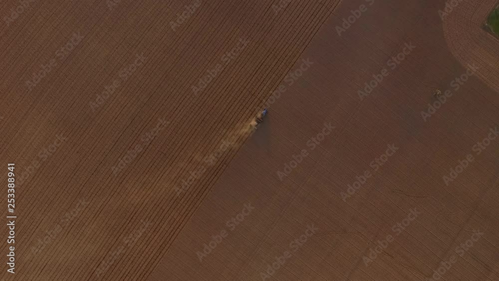 Sowing fields with tractor and seeder in dusty field aerial view Sowing fields with tractor and seeder in dusty field aerial view