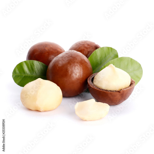 Macadamia nuts and green leaf isolated on white background
