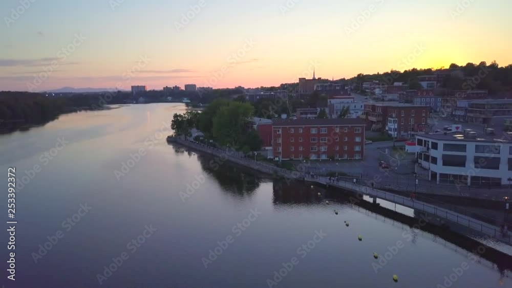 Drone slowly panning near downtown on a small city during sunset, with buildings, cars passing by and pedrestians wandering - summer season beautiful landscape. Drone slowly panning near downtown on a small city during sunset, with buildings, cars passing by and pedrestians wandering - summer season beautiful landscape.