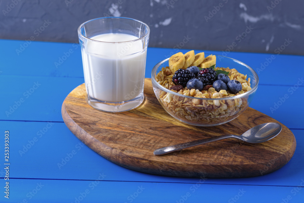 granola with a glass of milk on blue wooden background granola with a glass of milk on blue wooden background