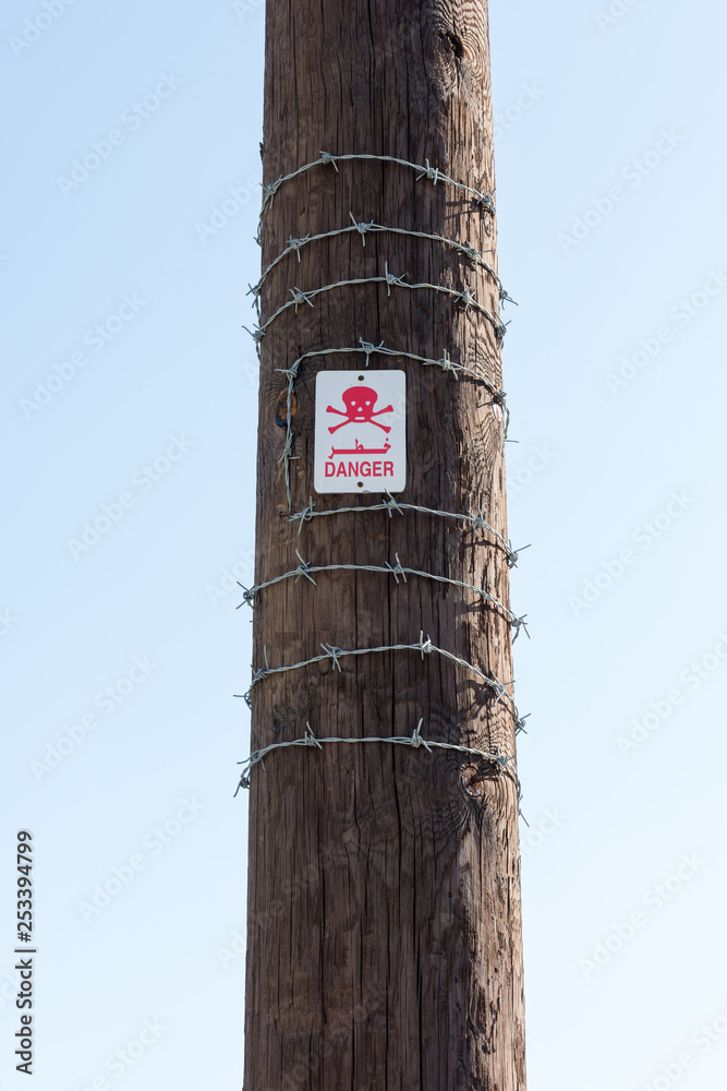 sign with symbol of danger on a wooden pillar