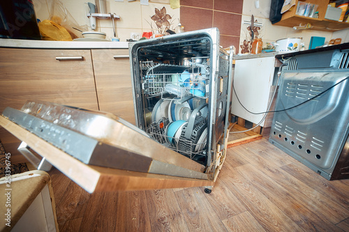 broken dishwasher with dirty dishes, problems with appliances in the kitchen