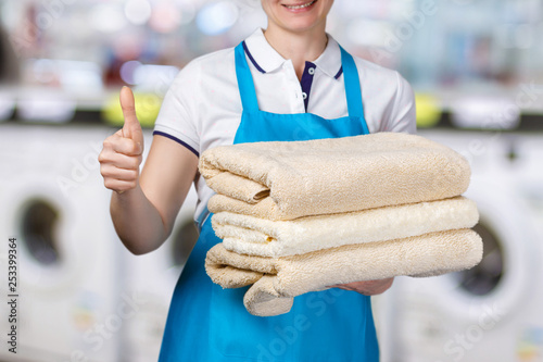 A laundry worker is holding clean towels.