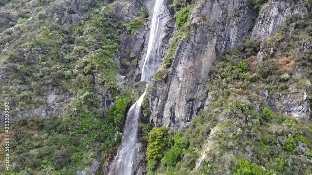 Track up impressive waterfall and its parent stream in New Zealand mountains Track up impressive waterfall and its parent stream in New Zealand mountains