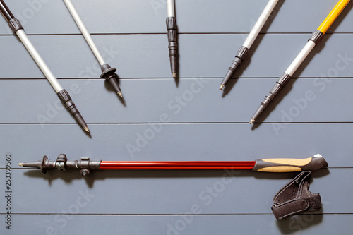 Flat lay top view of set of many hiking or ski poles on a wooden background photo