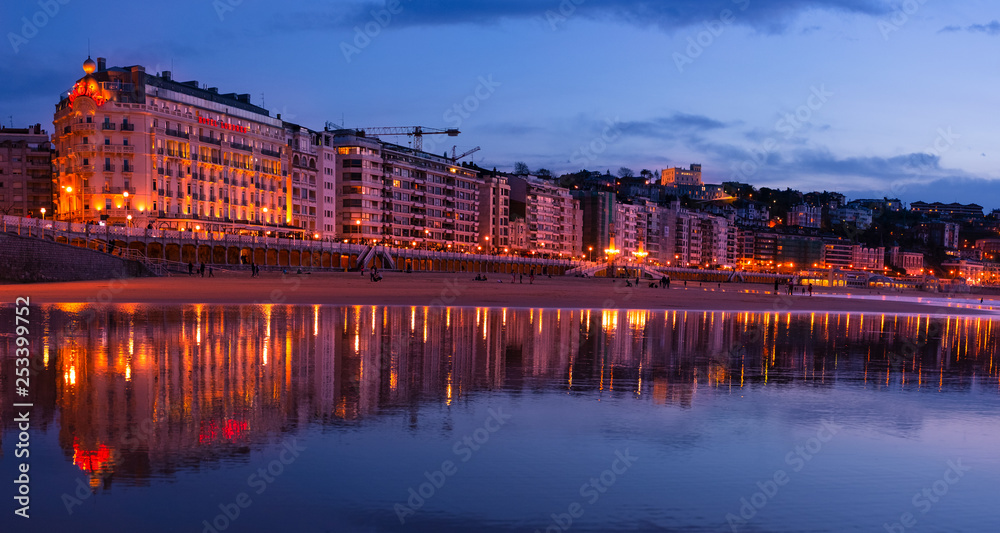 SAN SEBASTIAN, SPAIN - March 06, 2019: The buildings of the city are reflected in the water of La Concha beach in the city of Donostia