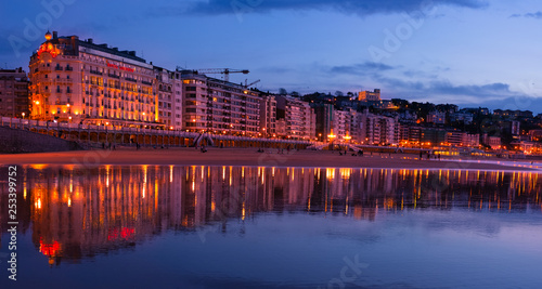 SAN SEBASTIAN, SPAIN - March 06, 2019: The buildings of the city are reflected in the water of La Concha beach in the city of Donostia