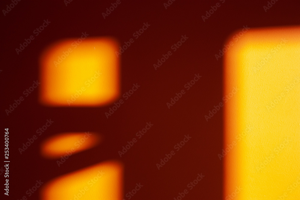 The abstract image on a painted wall. Reflection, numerous shadows on the wall. Bright light spots on the empty wall.