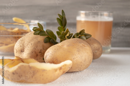 Juice with potatoes in a glass. Peeled potatoes.