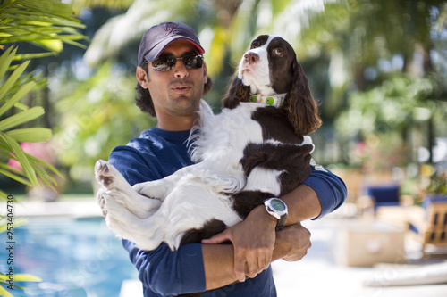 Mid-adult man carrying his spaniel.