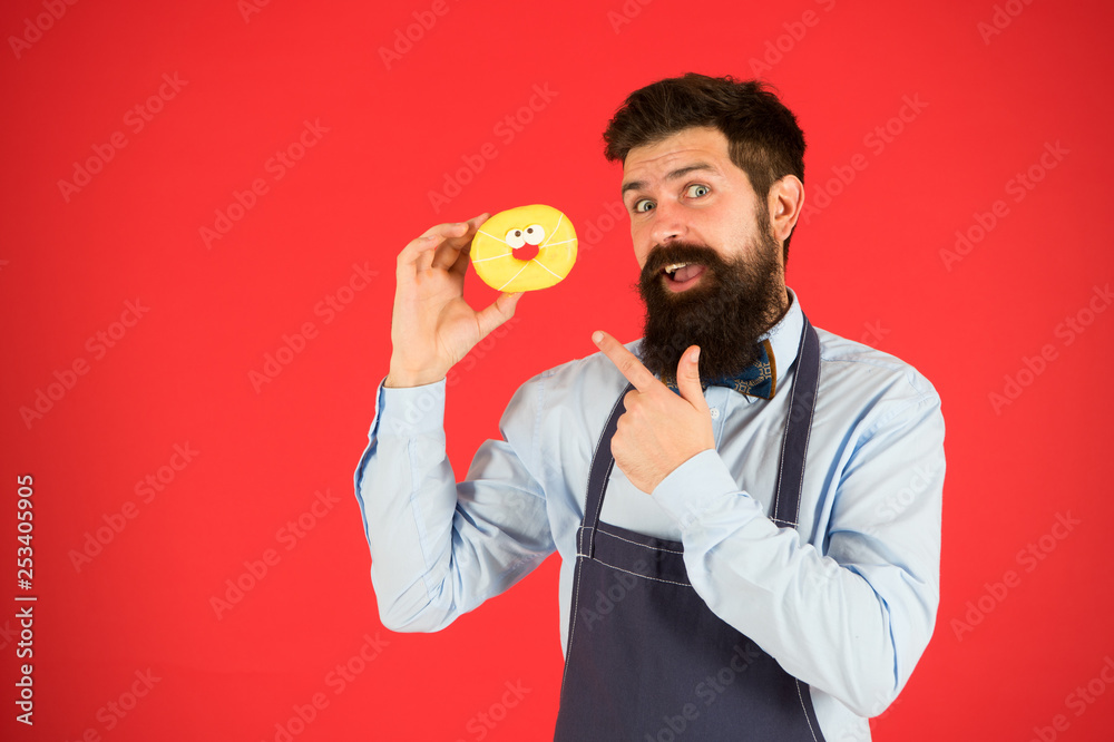 Cheat meal. Hipster bearded baker hold glazed donut on red background. Cafe and bakery concept. Sweet donut from baker. Man bearded baker in cooking apron hold cute dessert. Forget about diet Cheat meal. Hipster bearded baker hold glazed donut on red background. Cafe and bakery concept. Sweet donut from baker. Man bearded baker in cooking apron hold cute dessert. Forget about diet