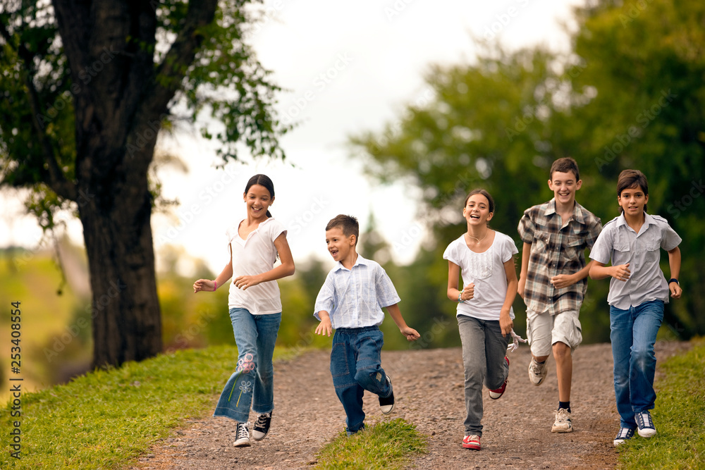 Small group of children running together over gravel road. Small group of children running together over gravel road.