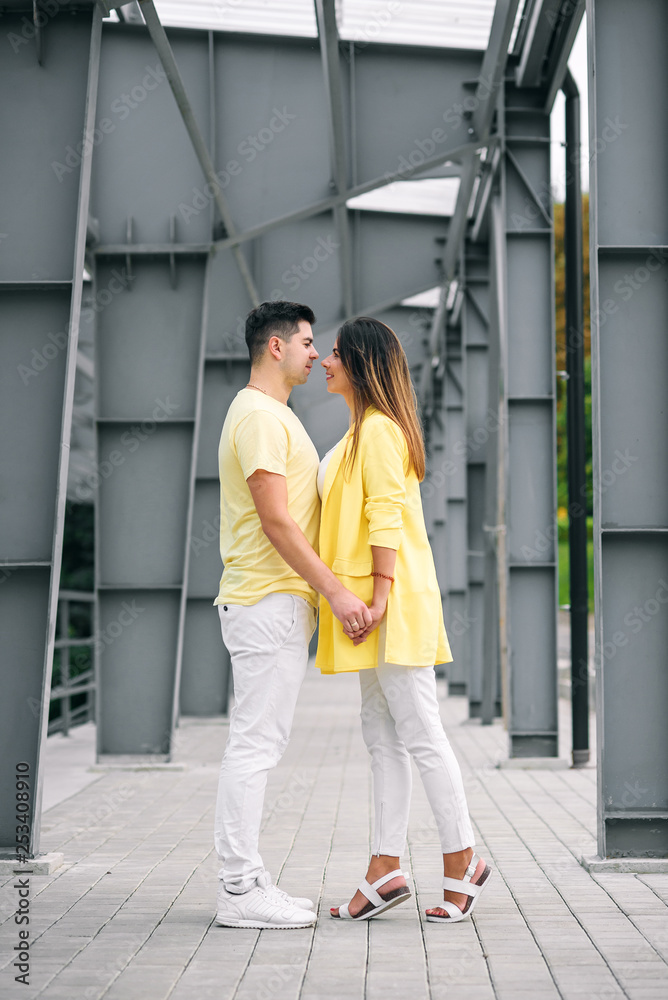 Lovely young couple in bright clothes holding hands