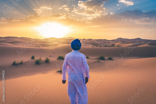 Berber man wearing traditional clothes in the Sahara Desert at dawn, Morocco photo