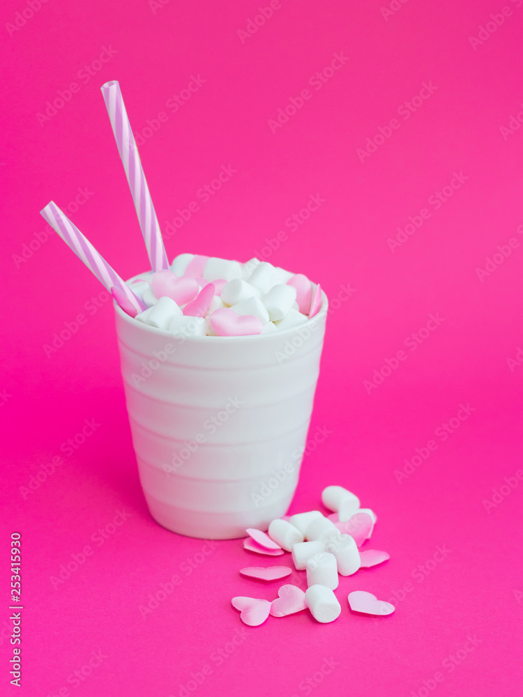 Mug with marshmallows in the shape of heart on pink background Mug with marshmallows in the shape of heart on pink background