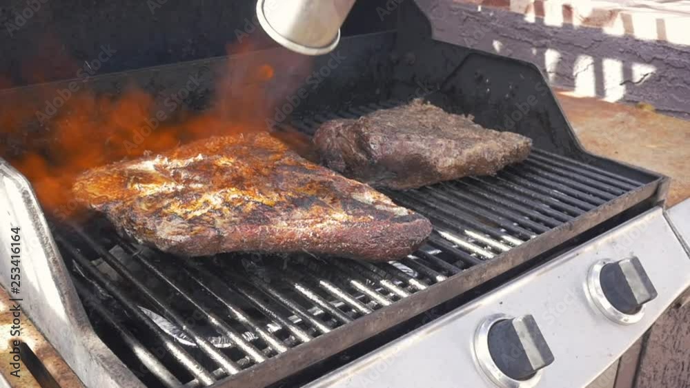 Torching BBQ beef brisket with a propane torch in slow motion. Flames