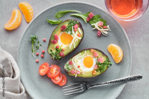 Keto diet dish: Avocado boats with ham cubes, quail eggs and cheese, top lay