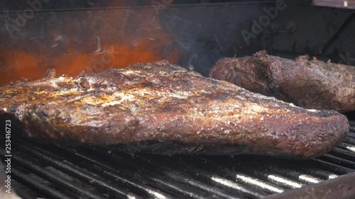 Flame grilling barbecue beef brisket in slow motion. Flames shoot from a propane torch, searing the smoked meat. Closeup of the grilled meat would be perfect for videos on competition barbecuing.