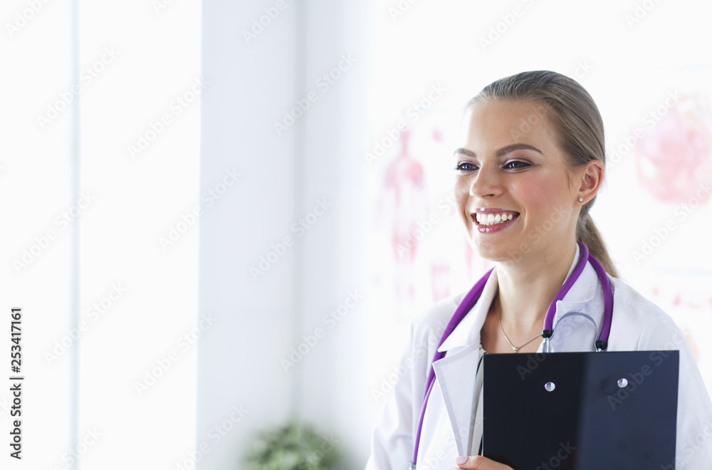 Smiling female doctor with a folder in uniform standing Smiling female doctor with a folder in uniform standing