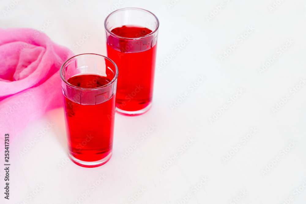 Fruit and berry red juice in glasses on a white background. Fresh and cold summer drink. Fruit and berry red juice in glasses on a white background. Fresh and cold summer drink.
