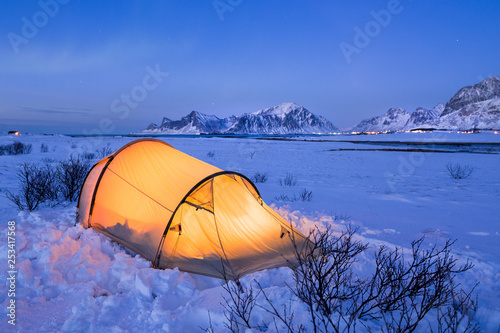 Illuminated tent at night on Lofoten islands in winter