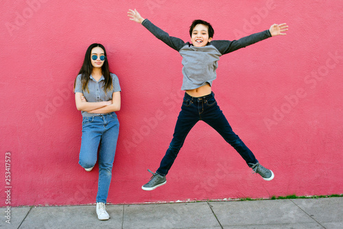 Canvas Print A little boy tries to impress his older sister by jumping high