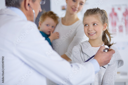 Girl and doctor with stethoscope listening to heartbeat