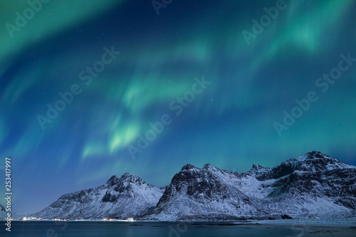 Beautiful northern lights over the snow covered winter landscape of the Lofoten islands
