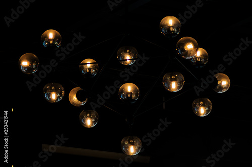 Close up many yellow, blue lamps in cafe, bar at night. round lamps isolated on black background. bokeh