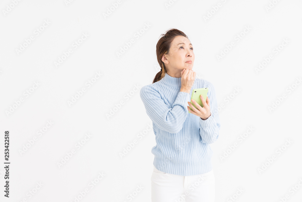 スマートフォンを見るシニア女性 考える スマートフォンを見るシニア女性 考える