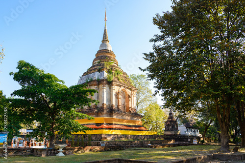 Outdoor scenery sunshine atmosphere of famous historical temple, Wat Jed Yod, and brick ruin pagoda and buddhist relief sculpture in Chiang Mai, Thailand.