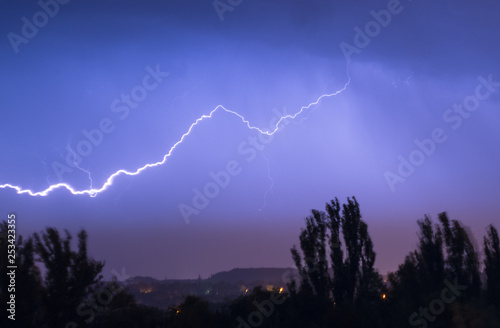Night lightning storm over city in blue dramatic lighting