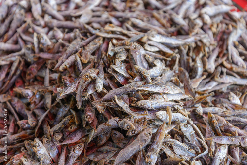 Close up view stack of small dried fish in outdoor seafood market.