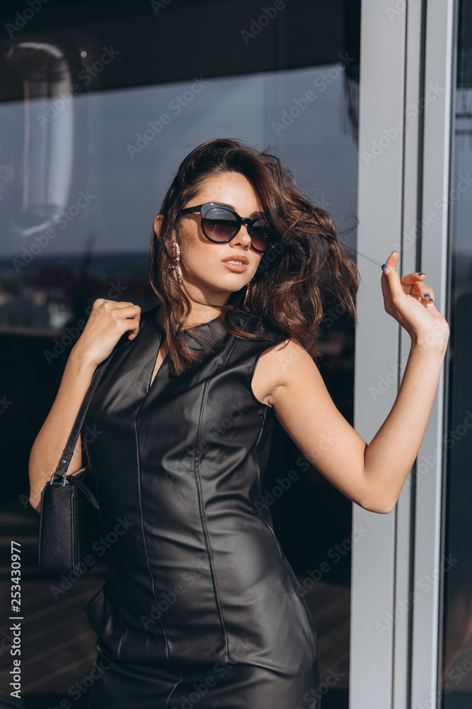 Glamour and sexy woman in black latex dress and sunglasses. фотография  Stock | Adobe Stock