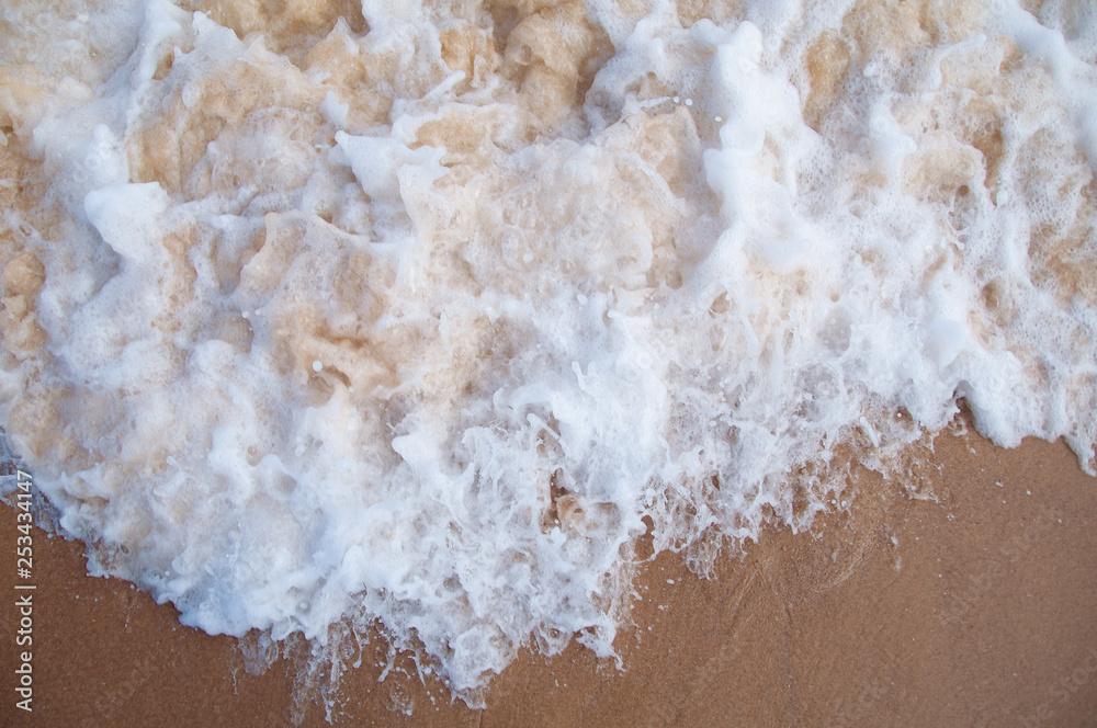 View from above on water froth, foam from wave on sand View from above on water froth, foam from wave on sand
