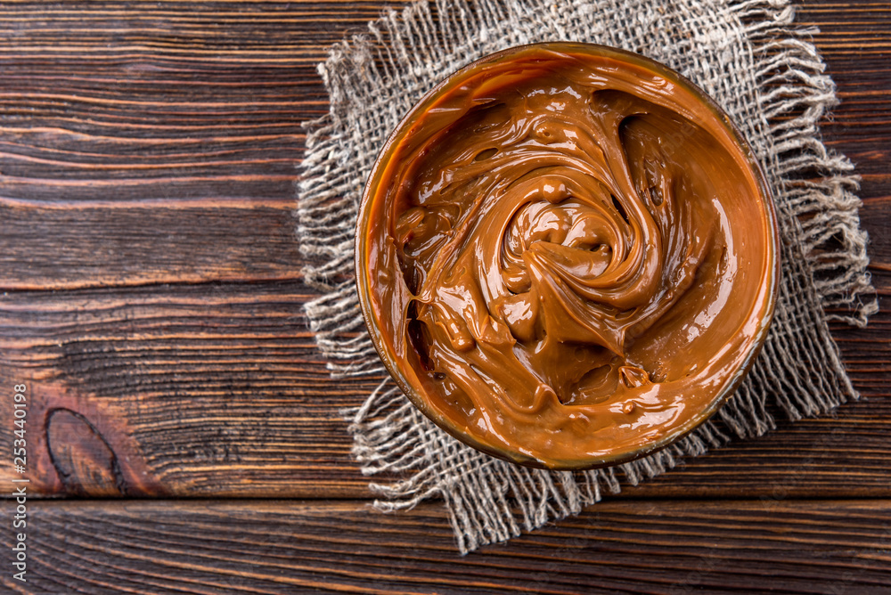 Boiled condensed milk on dark wooden background. Boiled condensed milk on dark wooden background.