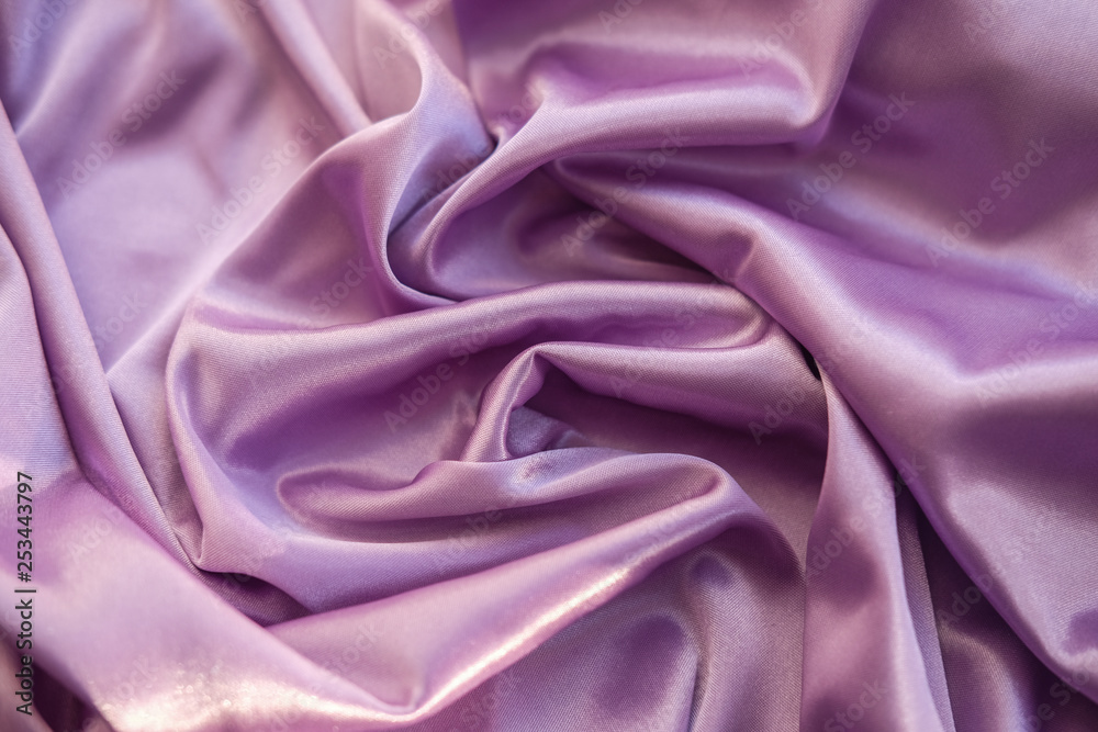 Obraz premium Close up pink fabric. The purple fabric is laid out waves. Fuchsia sateen fabric for background or texture.